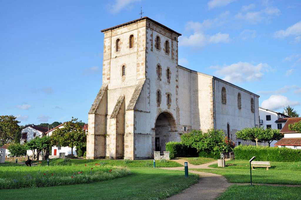 Église de Saint-Pée-sur-Nivelle entourée de verdure sous un ciel bleu