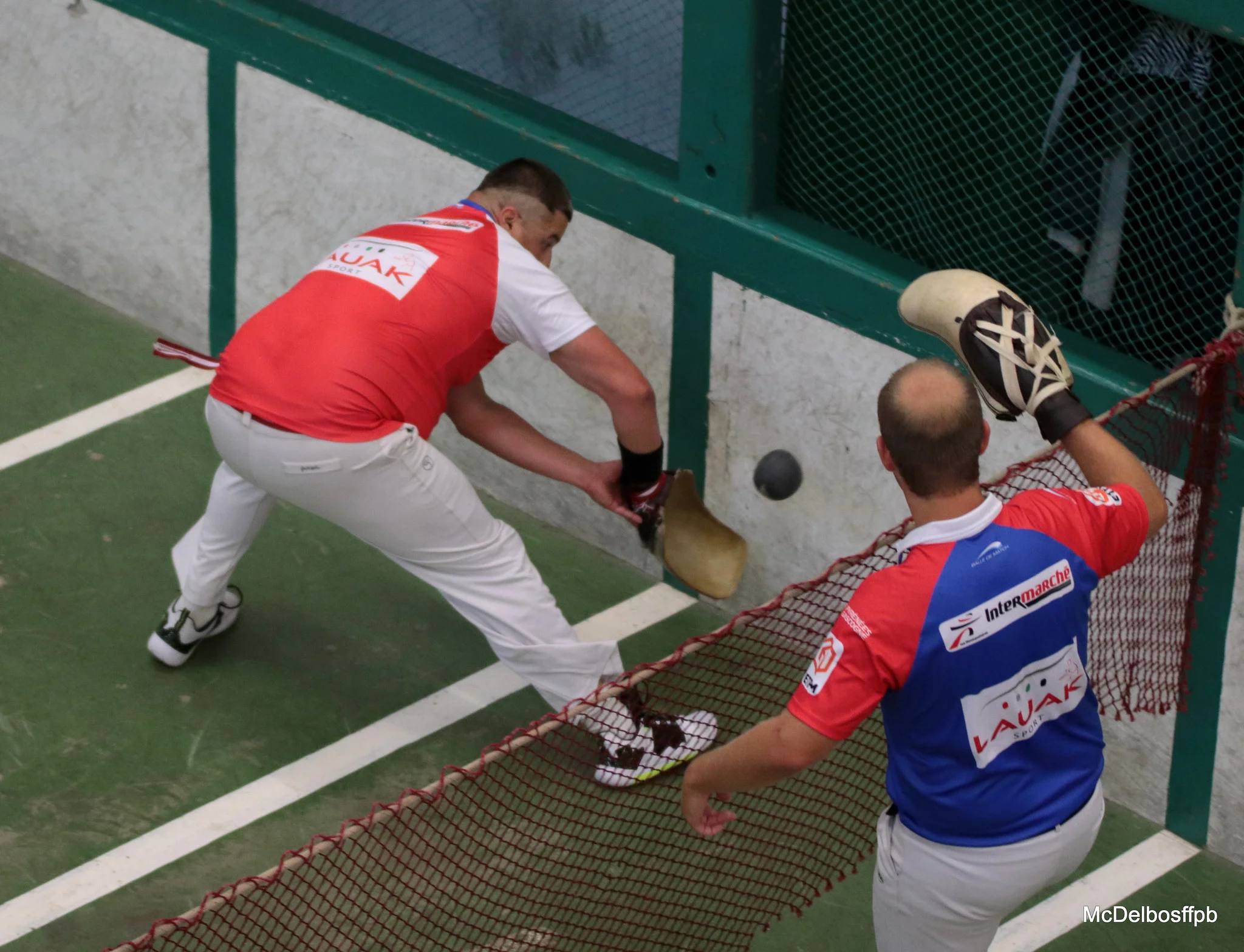 Partie de Pasaka dans un trinquet basque, joueurs en pleine action.