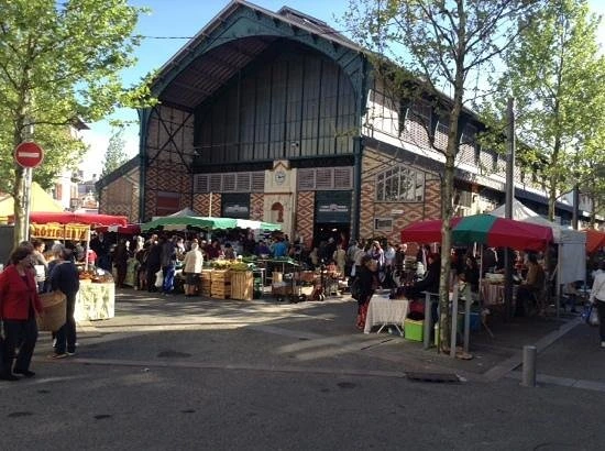Étal d'un marché traditionnel du Pays basque avec des fruits, légumes, fromages et produits locaux.